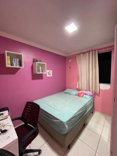 a small bedroom with a bed and a chair at Apartamento em condomínio COP30 in Marituba