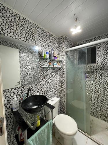 a bathroom with a toilet and a sink and a shower at Apartamento em condomínio COP30 in Marituba