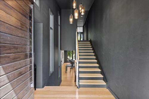 a staircase in a house with black walls and wooden floors at Romantic Lakefront Luxury - Spa Bath, Fireplace, King Bed in Daylesford