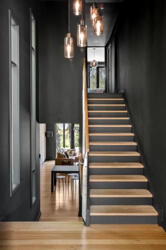 a staircase in a house with black walls and wooden floors at Romantic Lakefront Luxury - Spa Bath, Fireplace, King Bed in Daylesford
