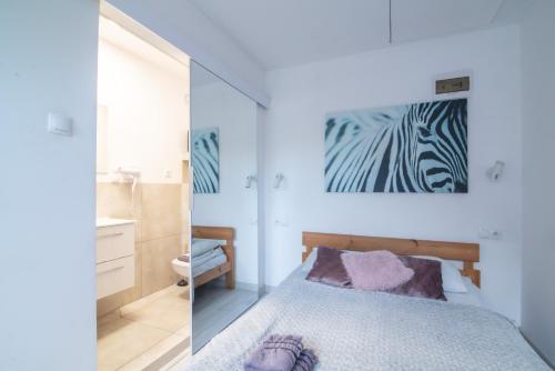 a bedroom with a bed and a painting on the wall at Studio I Pokoje I Pokoje z łazienkami in Gdańsk
