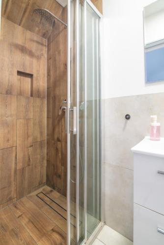 a shower with a glass door in a bathroom at Studio I Pokoje I Pokoje z łazienkami in Gdańsk