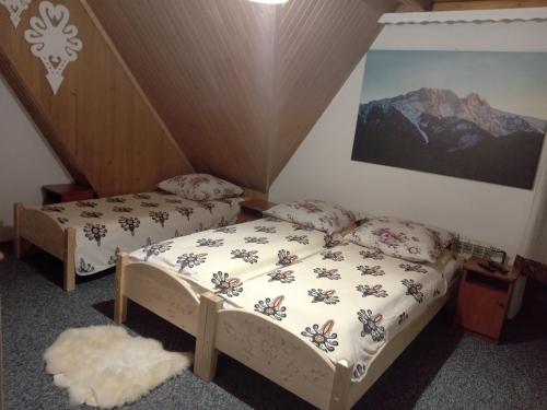 two beds in a room with a mountain at Pod Świerkami Białka Tatrzańska in Białka Tatrzanska