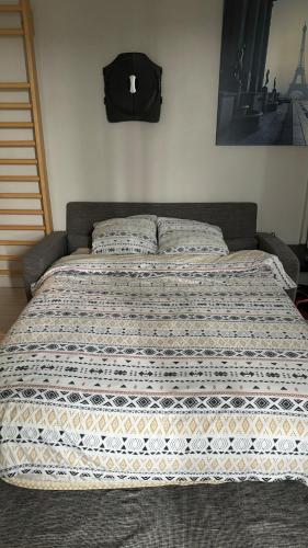 - un grand lit dans une chambre avec une couverture dans l'établissement Nice apartment in Saint Germain En Laye, à Saint-Germain-en-Laye