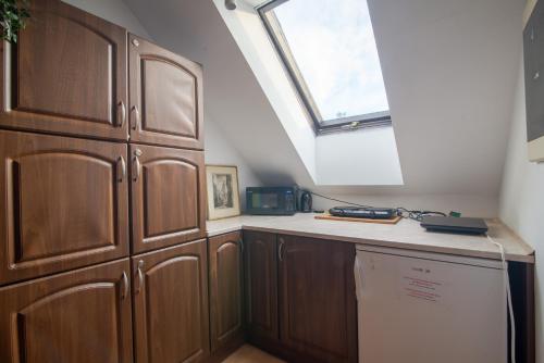 a kitchen with wooden cabinets and a window at Studio I Pokoje I Pokoje z łazienkami in Gdańsk