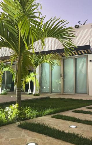 a building with palm trees in front of it at Villa Maty Casa Campestre in Turbaco
