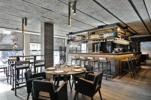 a restaurant with a table and chairs and a bar at Upper Diagonal in Barcelona