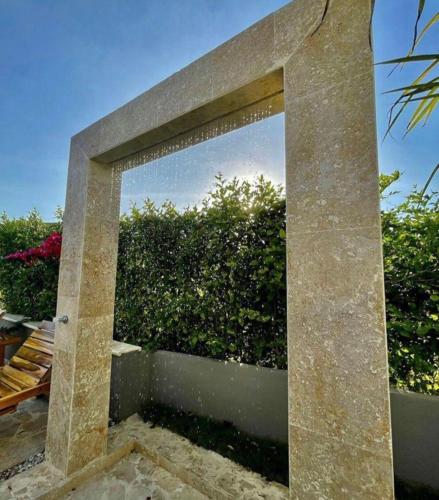 a large stone wall in front of a hedge at Villa Maty Casa Campestre in Turbaco