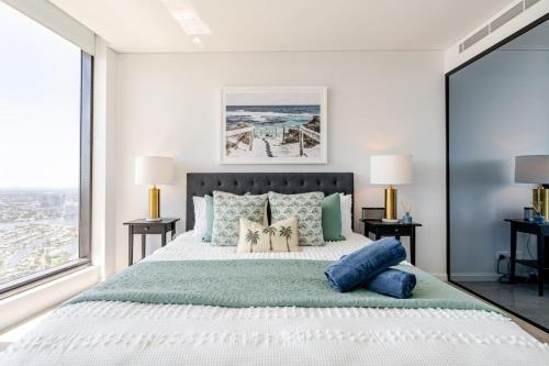 a bedroom with a large bed with blue pillows at Surfers Beachside Luxury - Stunning Panoramic View in Gold Coast