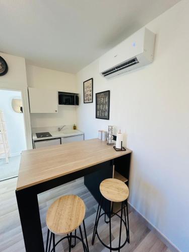 une cuisine avec un comptoir et deux tabourets dans l'établissement Appartement charmant proche Gare, à Tours