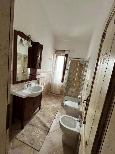 a bathroom with a sink and a toilet and a shower at Angelica's beachside apartment in Porto Columbu - Perdʼe Sali
