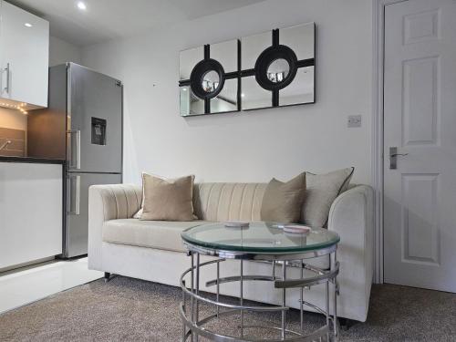a living room with a couch and a glass table at StayZen Apartments - Private Garden & Free Parking Ground Floor Central Woking - Business & Leisure in Woking