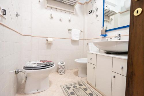 a white bathroom with a toilet and a sink at Materò House - Nel cuore di Alfedena in Alfedena