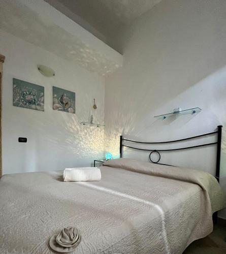 a bedroom with a large bed with a white blanket at Angelica's beachside apartment in Porto Columbu - Perdʼe Sali