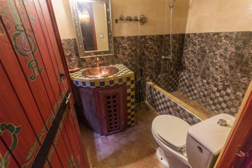 a bathroom with a sink and a toilet and a mirror at Ryad Bahia in Meknès