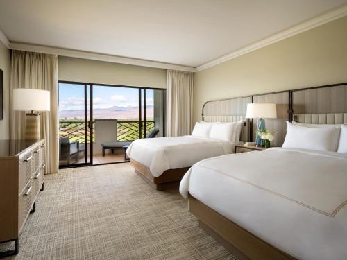a hotel room with two beds and a balcony at Fairmont Orchid in Waikoloa
