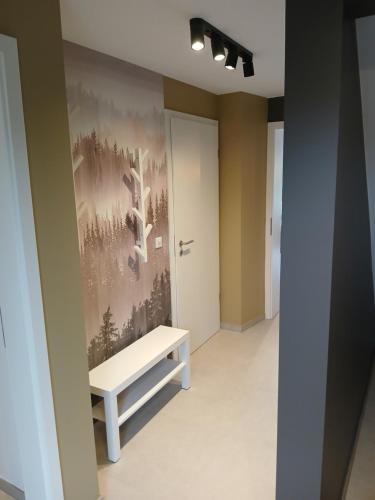 a bench in a hallway with a painting on the wall at Gite chez Martin in Jalhay
