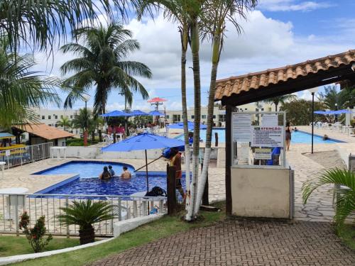 a pool at a resort with people in the water at Apartamento São Pedro da Aldeia frente para lagoa in São Pedro da Aldeia