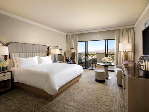 a bedroom with a large bed and a living room at Fairmont Orchid in Waikoloa