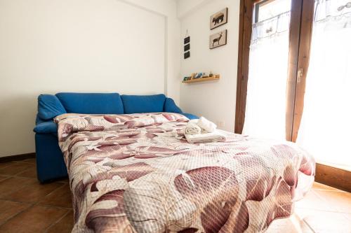 a bedroom with a blue couch and a bed at Materò House - Nel cuore di Alfedena in Alfedena