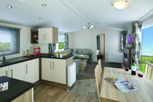 a kitchen and living room with a table and a dining room at Hokitika Holiday Park in Hokitika