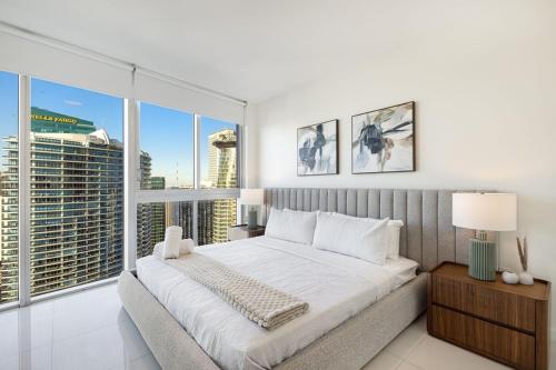 a bedroom with a large bed and large windows at Sky High Penthouse Corner 2BR 2BA Icon Brickell in Miami