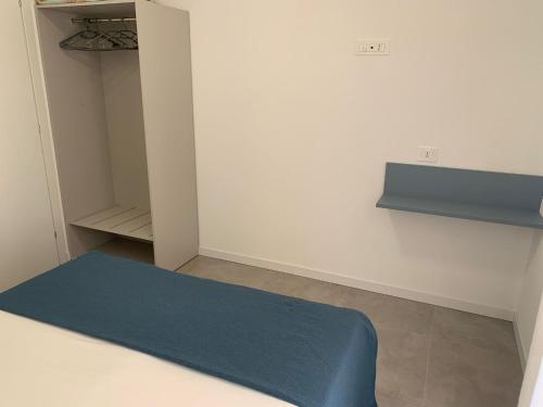 a small room with a bed and a shelf at Matilde Apartments Caorle in Caorle