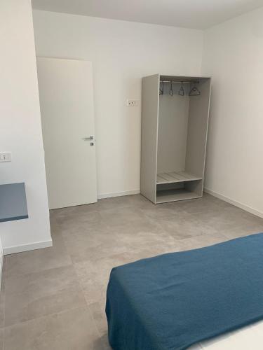 a white room with a bed and a closet at Matilde Apartments Caorle in Caorle