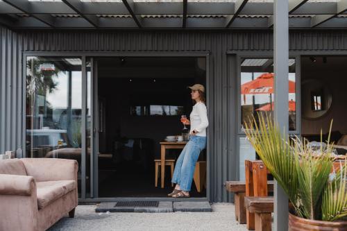 a woman standing in the doorway of a house at Lake Mahinapua Hotel in Ruatapu