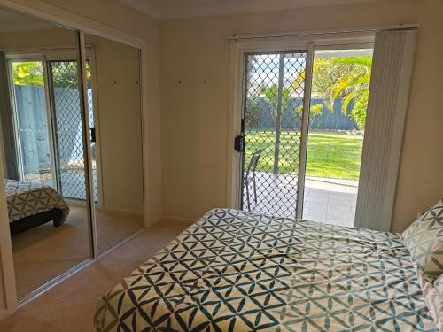 a bedroom with a bed and a sliding glass door at Bayside Bliss in Brisbane
