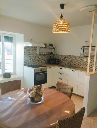 - une cuisine avec une table en bois et un bol de nourriture dans l'établissement MAISON comprenant 2 logements à louer ensemble ou séparément capacité jusqu'à 10 personnes plus 2 bébés Idéalement placé pour visiter le Mt St Michel, St Malo et ses alentours, à Saint-Marcan