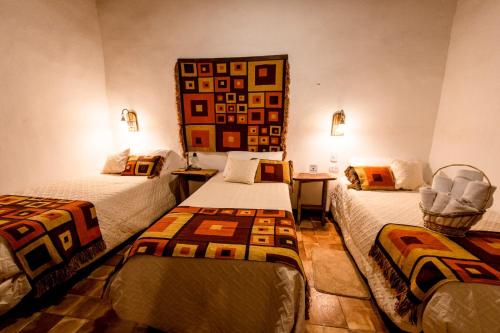 een kamer met 2 bedden en een spiegel aan de muur bij Hotel Boutique Watungasta in El Puesto