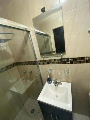 a bathroom with a sink and a shower and a mirror at Casa en renta cuarto in Navojoa