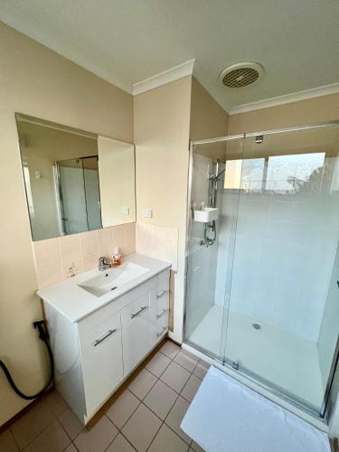 a bathroom with a sink and a shower at Spaven Heaven, Spacious and cosy home 4 min walk to the beach in Cowes