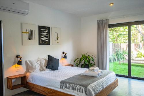 a bedroom with a bed and a large window at BarriOceano in El Paredón Buena Vista