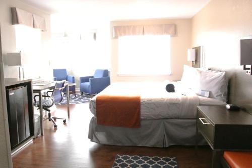 a hotel room with a bed and a table and chairs at Guesthouse Inn & Suites Lexington in Lexington