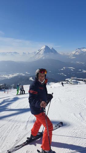 a man standing on skis on a snow covered slope at Alpenlandhaus Menardi in Seefeld in Tirol