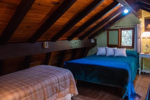 zwei Betten in einem Zimmer mit Holzdecken in der Unterkunft Apart del Bosque La Cumbrecita in La Cumbrecita