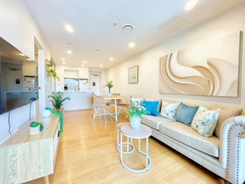 a living room with a couch and a table at Refreshing Central 2 Bedrooms on Queen St Living in Auckland