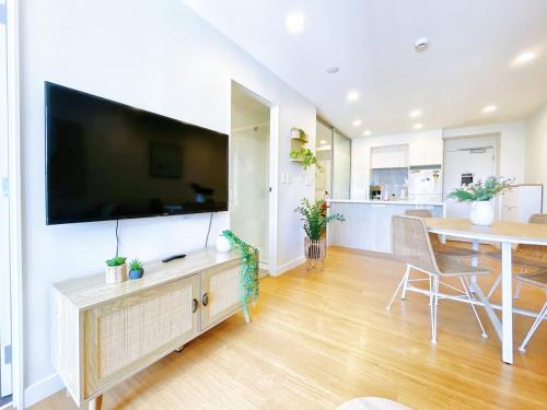 a living room with a large flat screen tv on a wall at Refreshing Central 2 Bedrooms on Queen St Living in Auckland