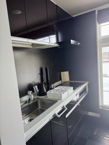 a kitchen with a sink and a counter top at BIEI TERRACE 1st Floor - 1F専用独立玄関 - 1F占有78平米大型ワンルーム- ソファベッド7台, 170型米Valerion社製最新シアター動画視聴, 無料Wi-Fi, シャワー, ミニキッチン付き - 駅前通り沿い - in Biei