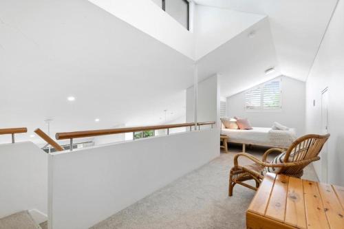 a living room with white walls and a table and chairs at The Noosa Apartments in Noosa Heads