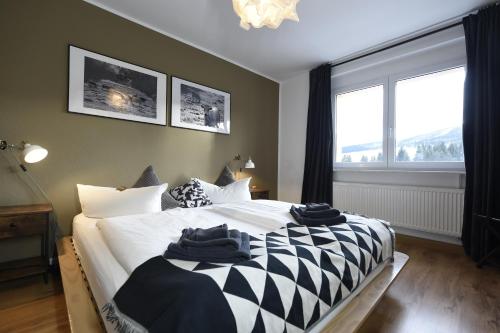 a bedroom with a bed with black and white sheets at Oberwiesenthal Apartments in Kurort Oberwiesenthal