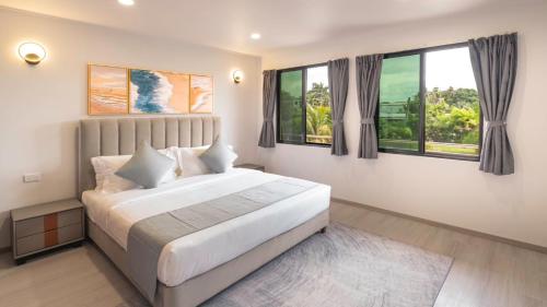 una camera con un grande letto e due finestre di Hibiscus Suites And Residences a Nadi