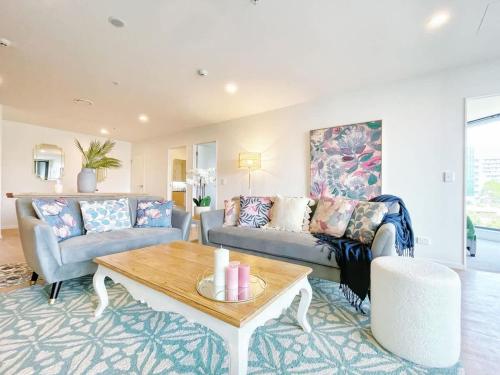 a living room with a couch and a table at Unique Luxury Incredible SkyTower & Park View - Free Parking in Auckland