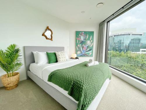 a bedroom with a bed and a large window at Unique Luxury Incredible SkyTower & Park View - Free Parking in Auckland