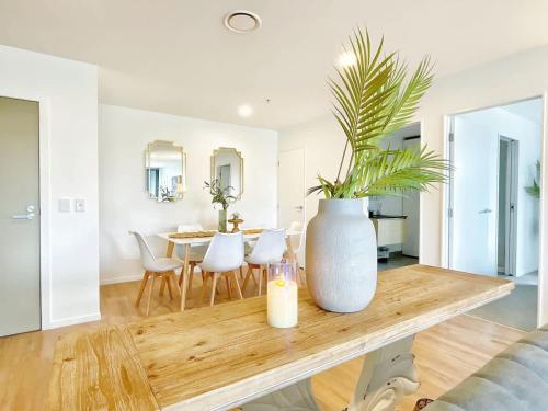 a living room with a table with a vase on it at Unique Luxury Incredible SkyTower & Park View - Free Parking in Auckland