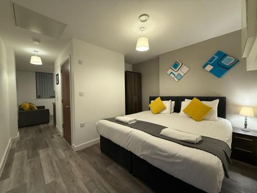 a bedroom with a large bed with yellow pillows at Liverpool One City Centre Studio Apartment in Liverpool