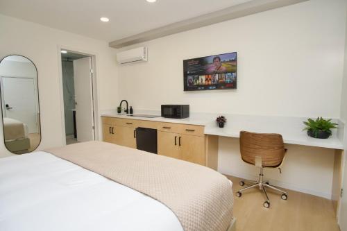 a bedroom with a bed and a desk and a mirror at Rio Suites in Tijuana