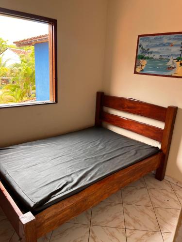 a bed in a room with a window at Kitnet Elles in Marau